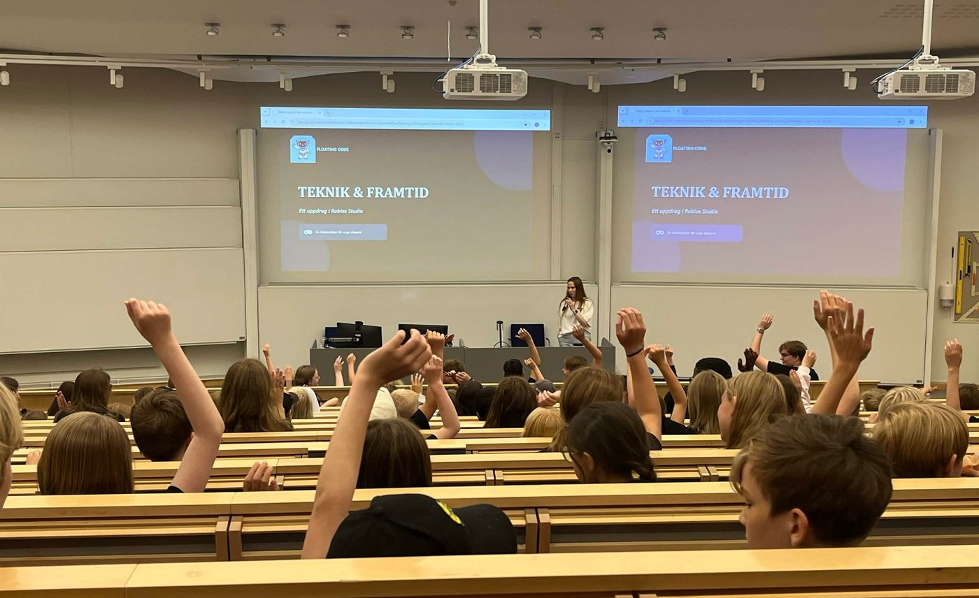Angelica föreläser om Teknik och framtid i en hörsal full av barn som räcker upp handen